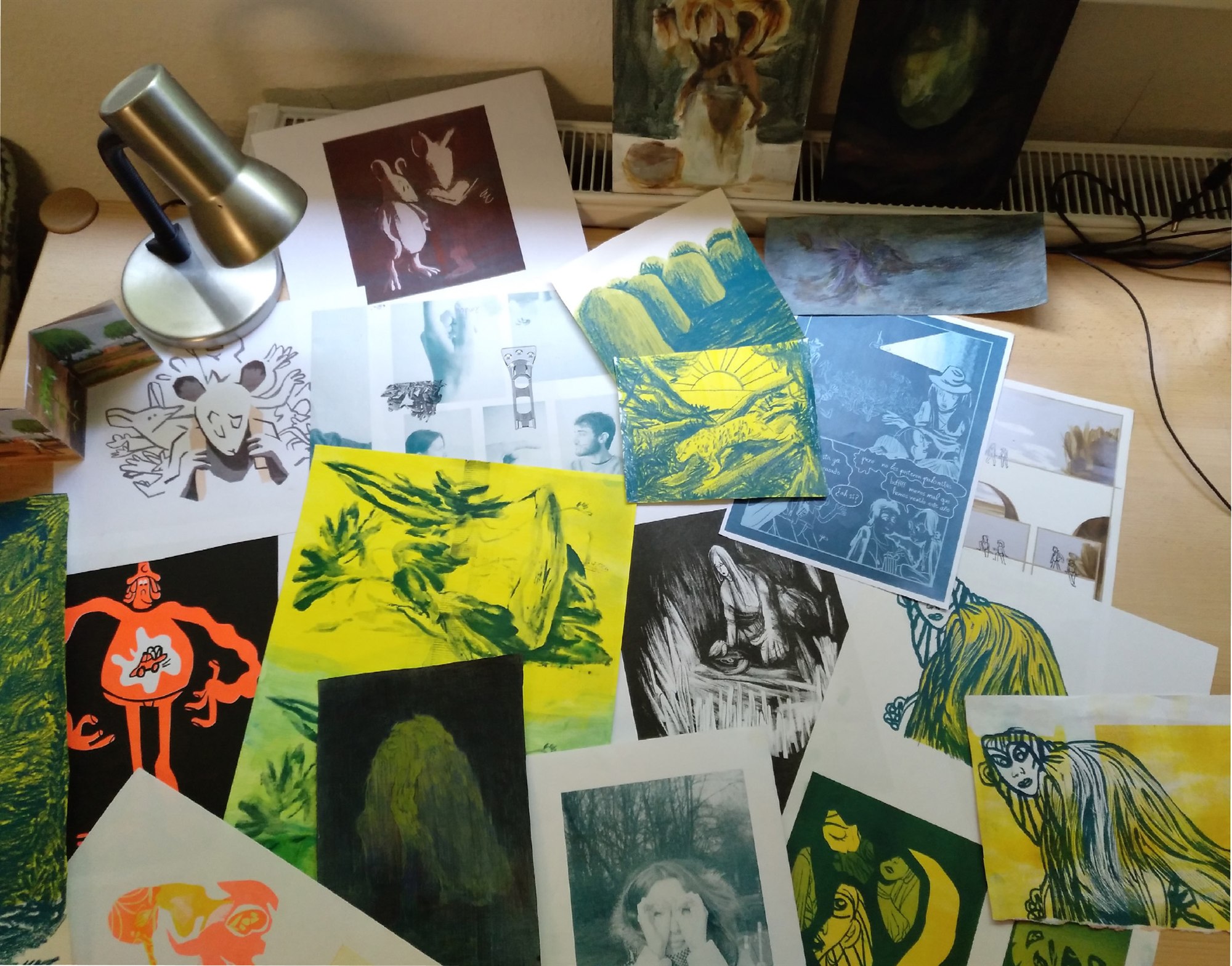 Mesa de trabajo cubierta de dibujos, pinturas e ilustraciones